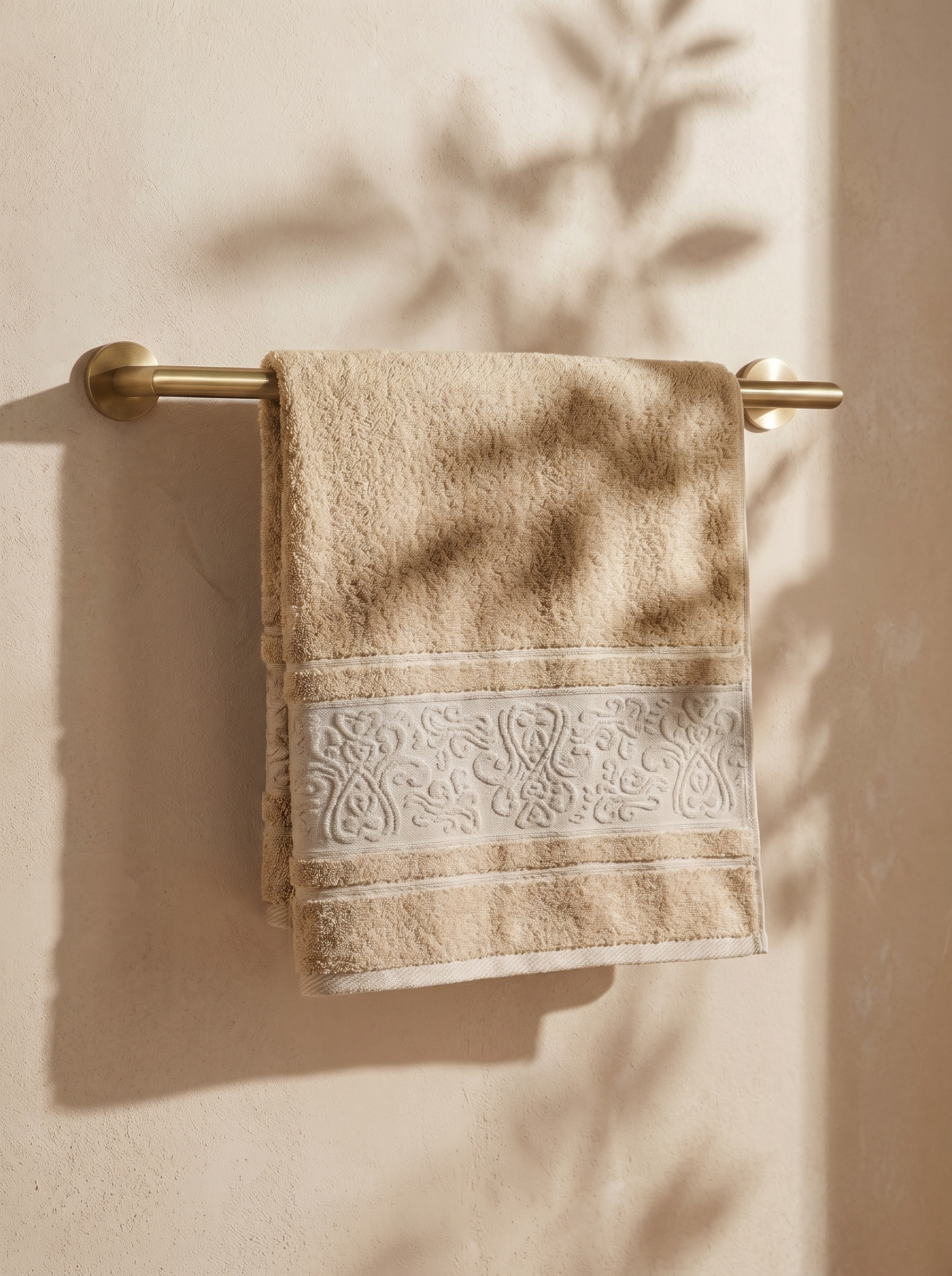 Linoa 450 Hudoo in sand 100% cotton towel, draped over a rail
