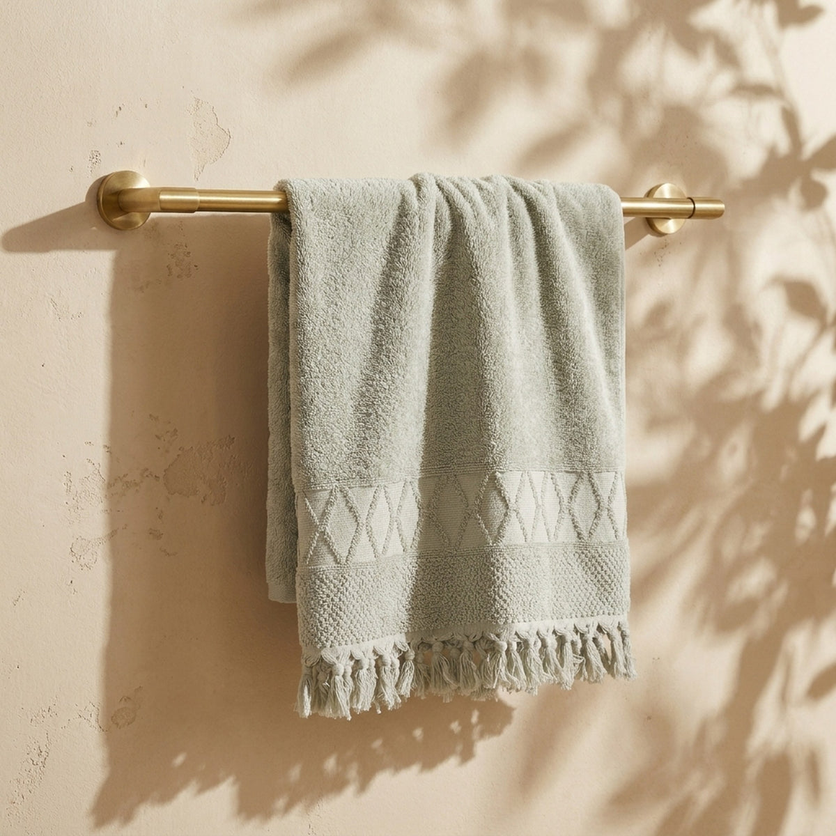 Linoa 450 Sakeena in sage green 100% cotton towel, draped over a rail
