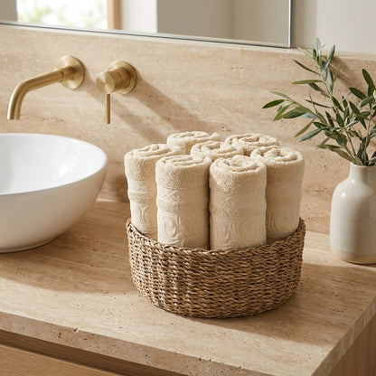 Linoa 550 Reesha Feather in off-white 100% cotton towel, face towel folded in a woven basket