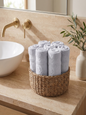 Linoa 550 Reesha Feather in white 100% cotton towel, face towel folded in a woven basket