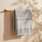 Linoa 650 Fakhm Luxe in grey 100% cotton towel, draped over a rail, rose-medallion border