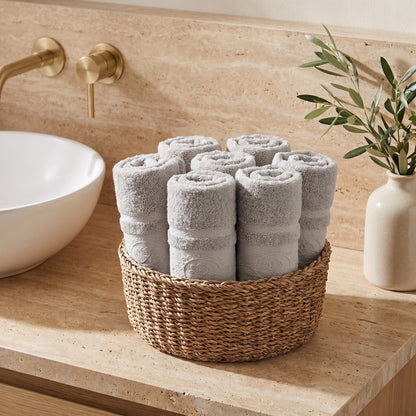 Linoa 650 Fakhm Luxe in grey 100% cotton towel, face towels folded in a woven basket, rose-medallion border