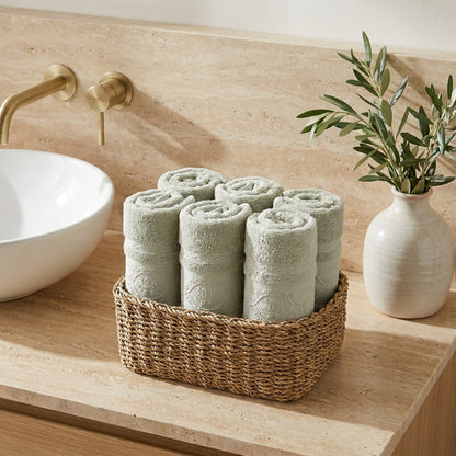 Linoa 650 Fakhm Luxe in sage green 100% cotton towel, face towel folded in a woven basket