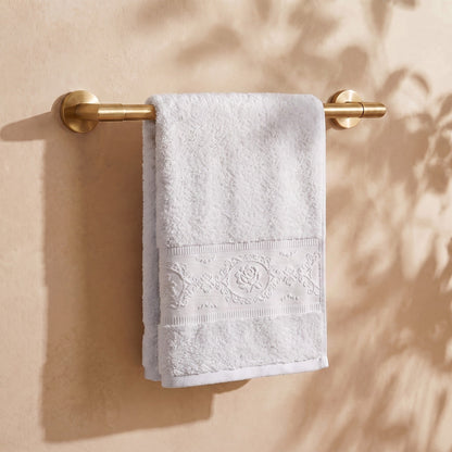 Linoa 650 Fakhm Luxe in white 100% cotton towel, draped over a rail, rose-medallion border