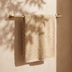 Linoa 650 Naem+ Spa in sand tan 100% cotton towel, draped over a rail