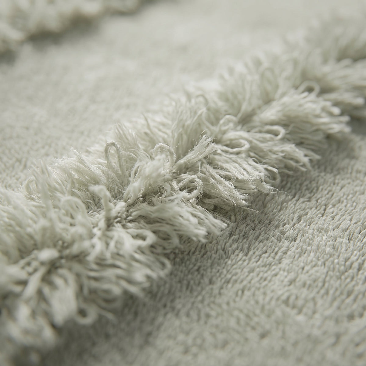 Linoa 650 Naem+ Spa in sage green 100% cotton towel, macro close-up of the raised tufted stripe weave
