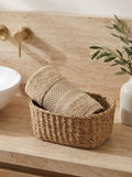 Linoa 550 Naeem in sand 100% cotton towel, face towel folded in a woven basket